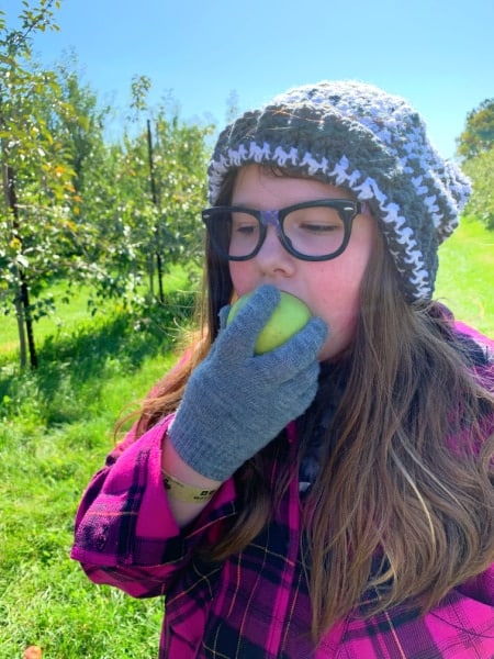 fall apple recipes easy apple sticks - teen girl eating a fresh picked apple