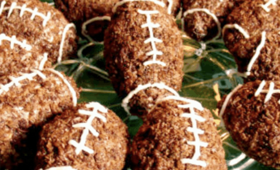 Chocolate Rice krispie footballs rice crispy treats shaped like footballs on a plate