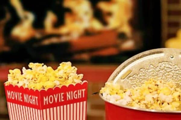 The best Christmas movies list with popcorn in front of a winter fire
