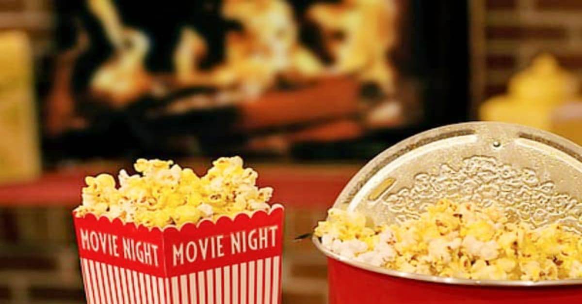 The best Christmas movies list with popcorn in front of a winter fire