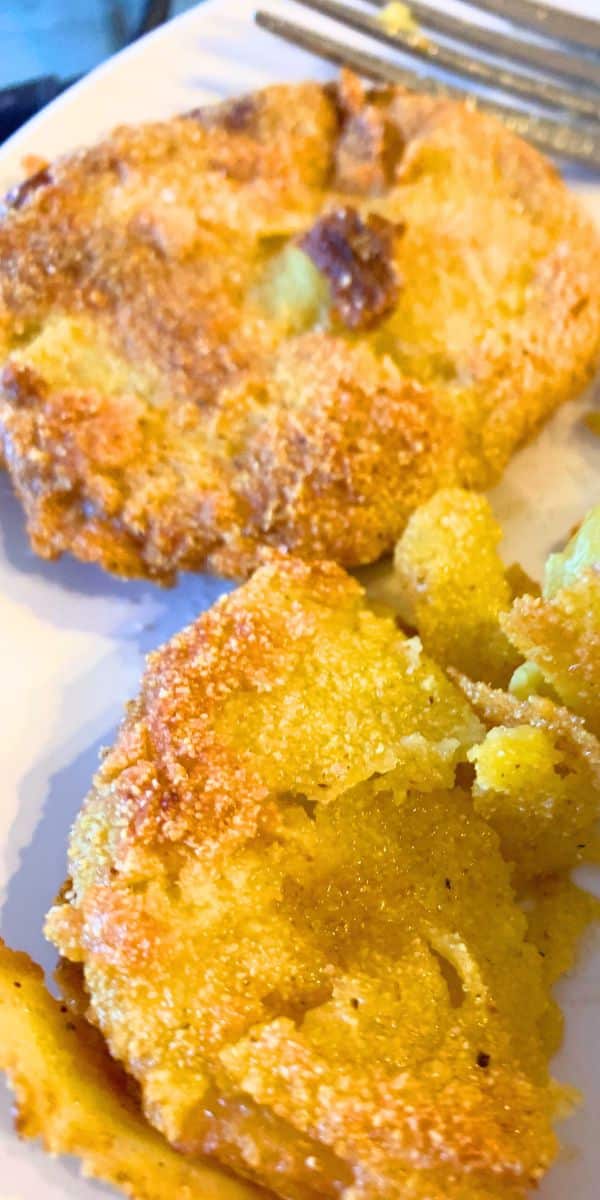 How To Make Fried Green Tomatoes Step By Step (FREE RECIPE PRINTABLE) - green fried tomatoes on a white plate with a fork