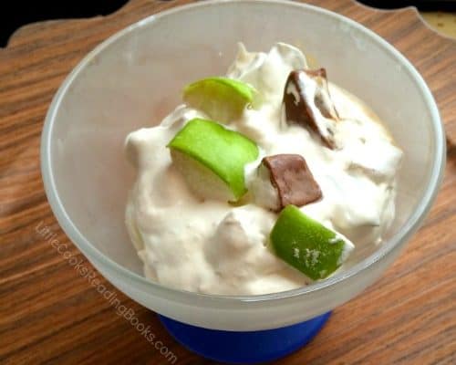 Snicker salad recipe with apples dessert dish with whipped cream, apples, and snickers bits