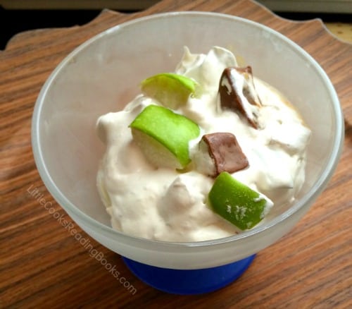 Snicker salad recipe with apples dessert dish with whipped cream, apples, and snickers bits