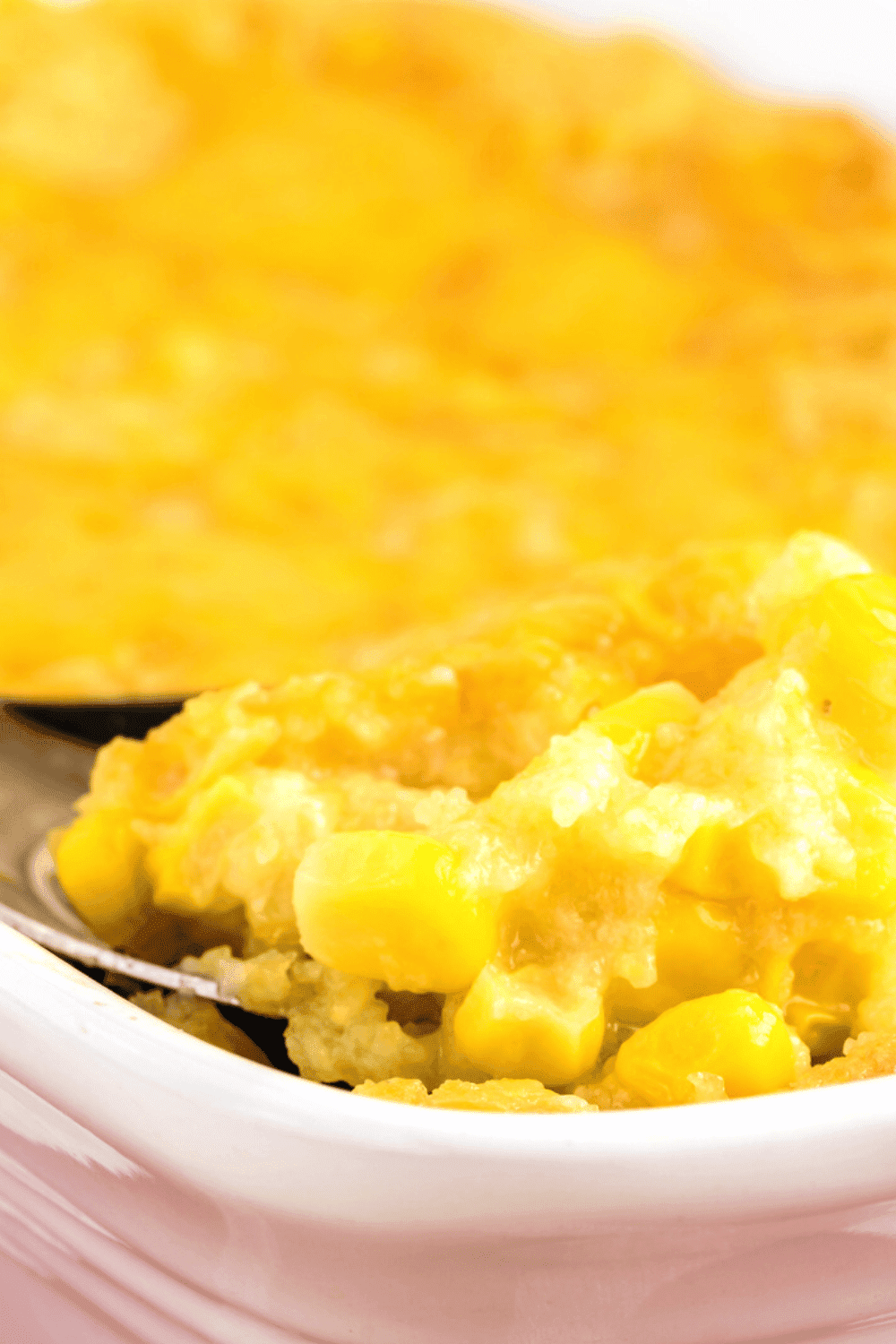 How To Make Corn Casserole In Slow Cooker or Oven close up of corn pudding on spoon