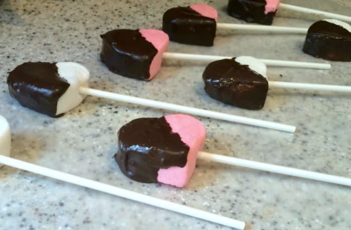 How To Make Marshmallow Pops For Valentine's Day Candy pink and white heart marshmallows dipped in chocolate on one side