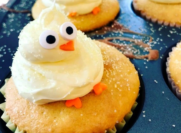 best cupcakes for spring: yellow baby chick piped out of icing and sitting on a yellow cupcake