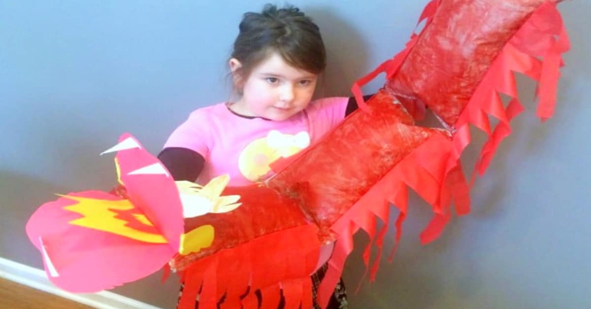 Chinese New Year dancing dragon craft for kids young girl holding Chinese dancing dragon puppet