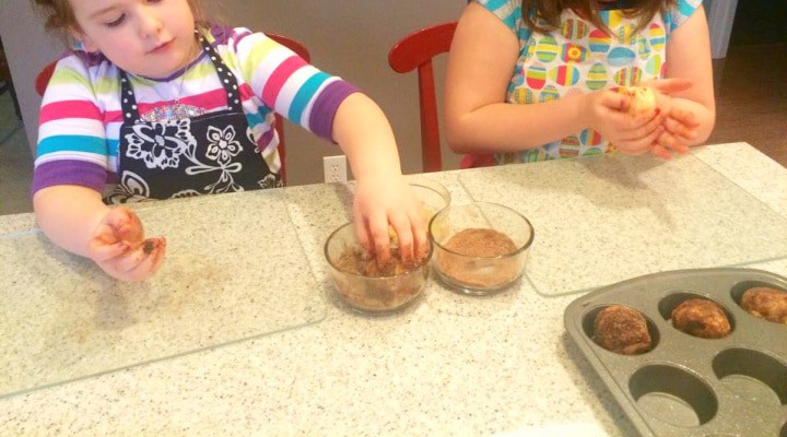 Two young girls making The old fashioned God roll (resurrection rolls project, aka: Easter rolls recipe) dipping rolled dough into cinnamon