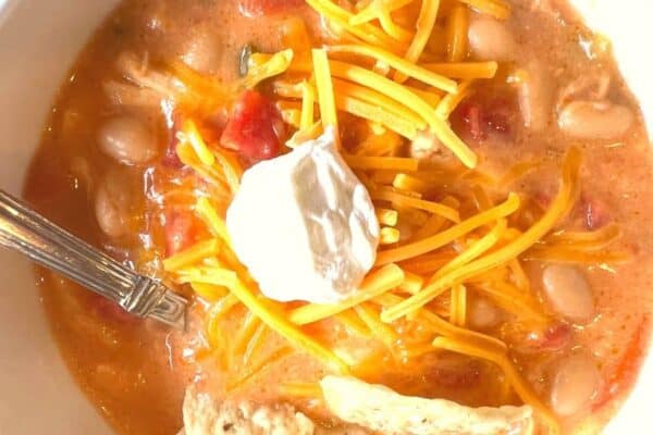 Simple White Bean Chicken Chili Made With Salsa with sour cream dollop in a bowl with spoon