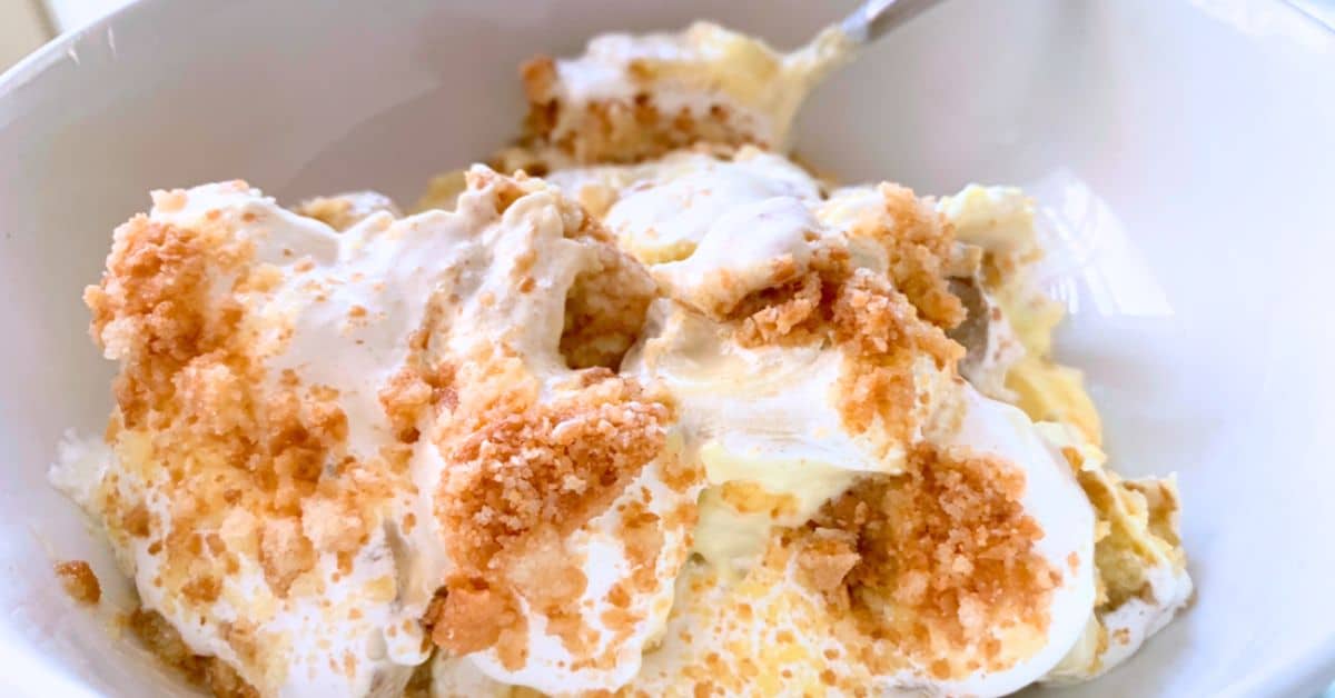 How To Make Banana Pudding Homemade No Cook Old-Fashioned Homemade Banana Pudding from scratch in a white bowl with spoon - great for Banana Dessert Recipes, Dessert Dips, Pudding Desserts or Mini Desserts