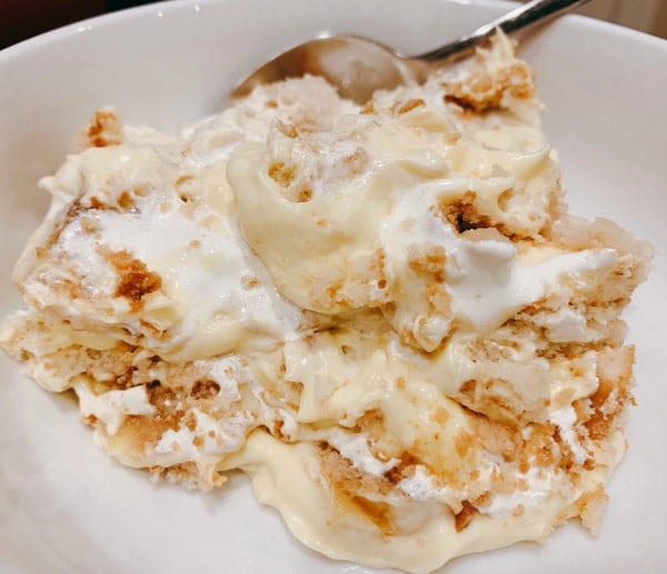 How To Make Banana Pudding Homemade close up banana pudding in white bowl with spoon