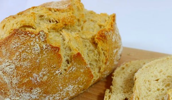 Sourdough Starter Bread Recipe loaf of sourdough bread on brown cutting board