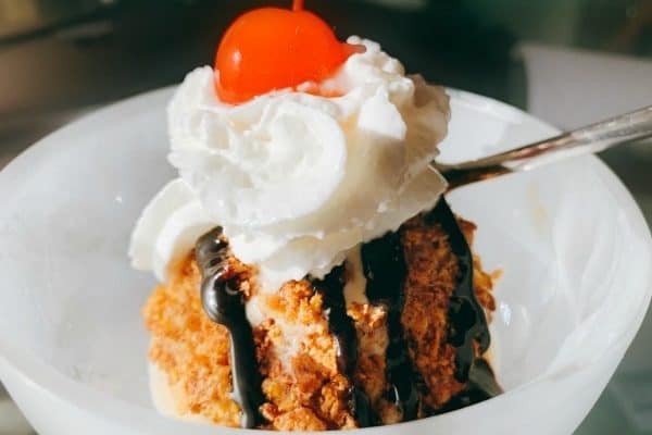 Recipe For Fried Ice Cream fried ice cream with chocolate syrup drizzled over it and whipped cream with a cherry