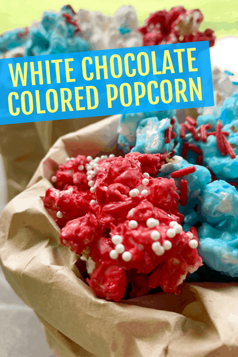 white chocolate covered popcorn in red white and blue colors in a brown paper bag