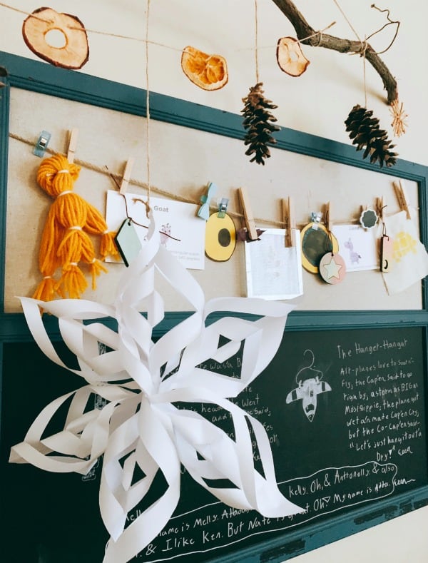 How To Make A Garland For Christmas dried fruit and pinecones hanging on twine over a bulletin board