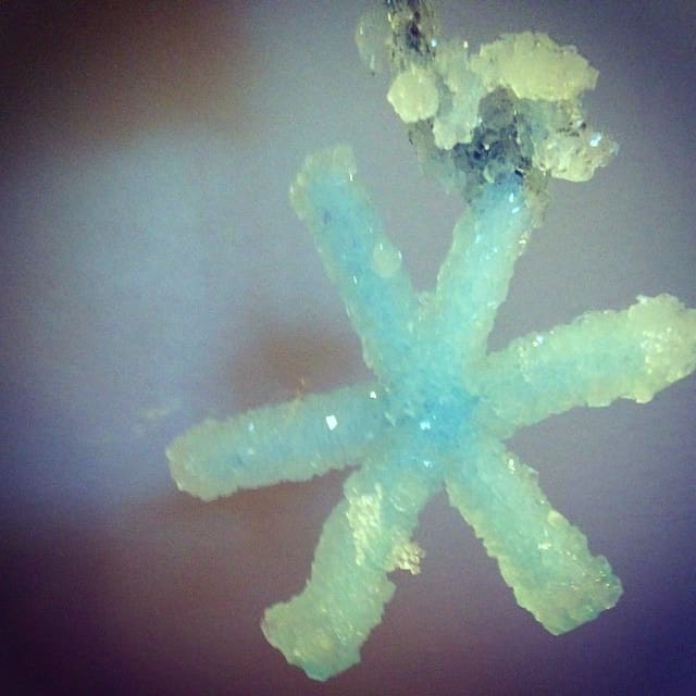 Borax Snowflake with blue tint against dark colored background