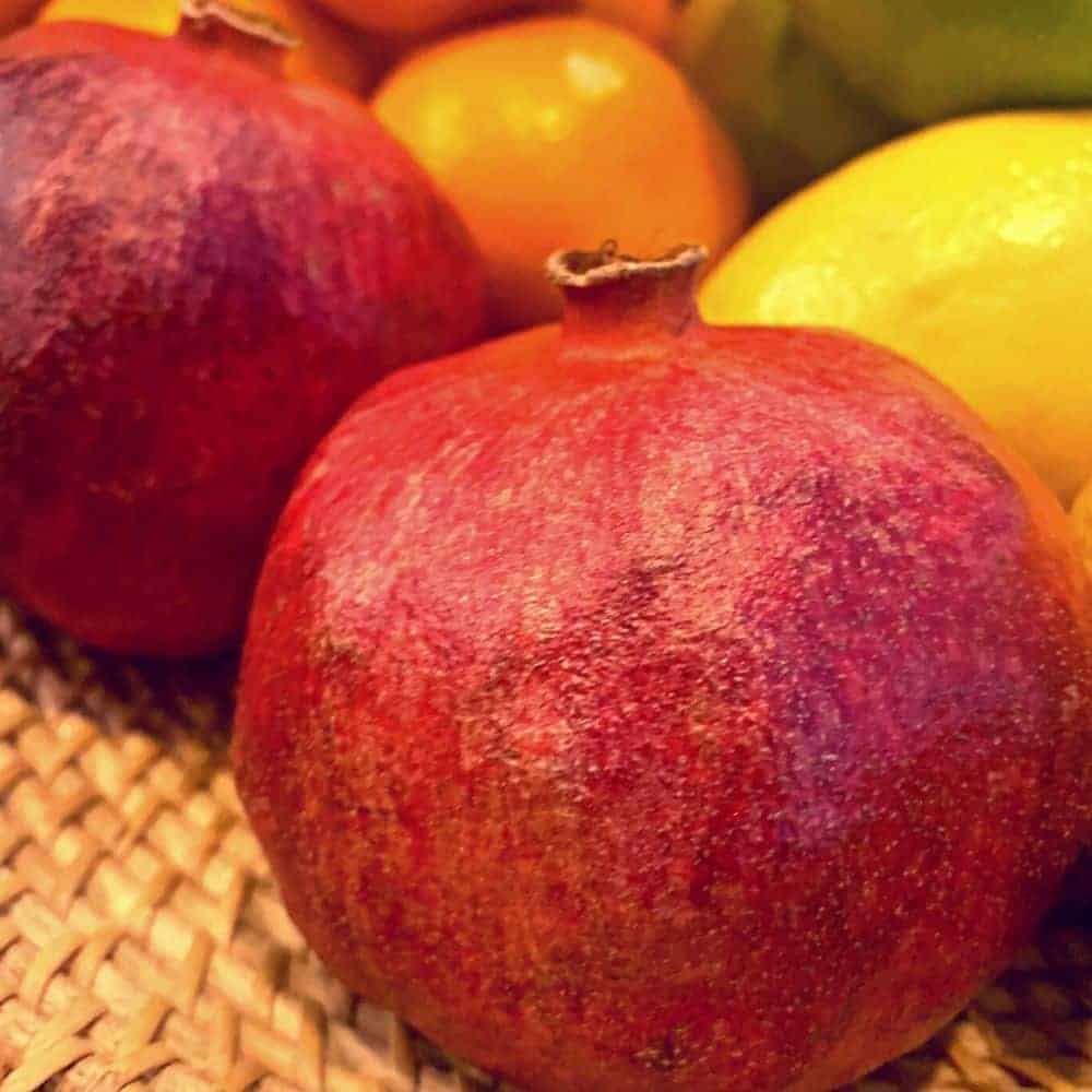 Pomegranate Round Fruit with Beautiful Color in basket of fruits 