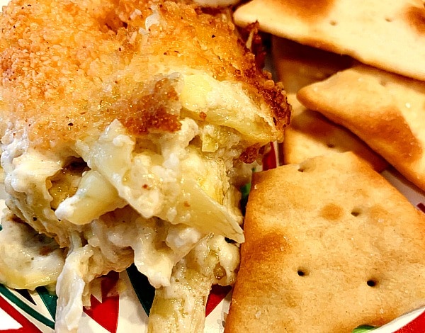 Easy Artichoke Dip Recipe on a plate with crackers