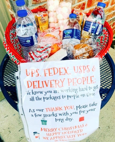 How To Make a Snack Basket For Delivery People (and What To Put On A Delivery Driver Sign for Snacks) porch snack basket filled with waters and snack items on a small table