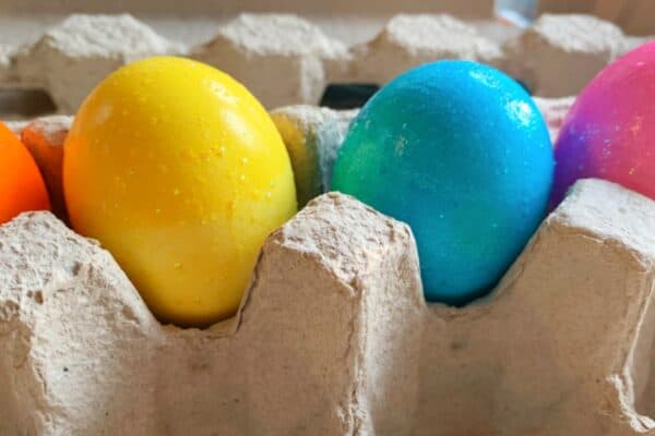 Using food color to dye eggs vibrant colored easter eggs sitting in an egg carton
