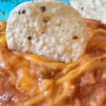 Refried Bean Dip with tortilla chip sticking in it