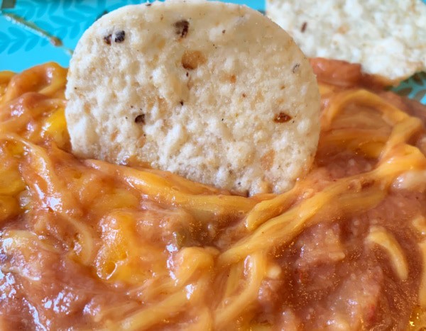 Refried Bean Dip (warm bean dip recipe) with tortilla chip sticking in it