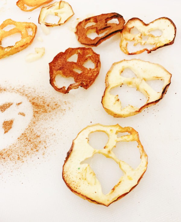 creepy Halloween treats air fryer apples - apple slices carved into Halloween monster faces and air fried apples