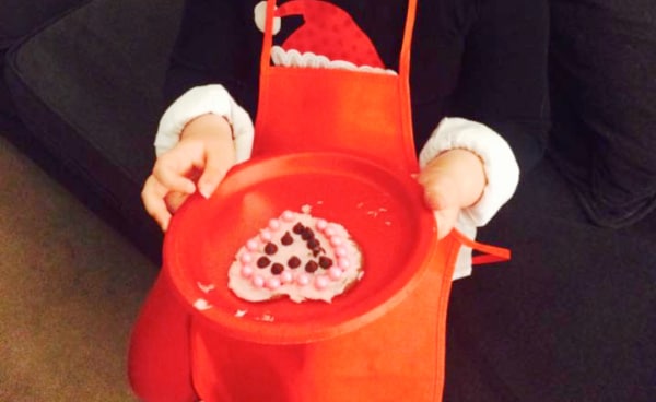 Sugar Cookie Recipe To Decorate for Cookie Party child's hand holding a decorated sugar cookie on a red plate