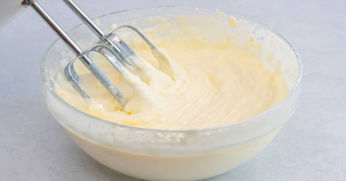 Cream Cheese Frosting for Pumpkin Cookies in a bowl with a mixer mixing it