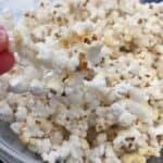 RECIPE FOR KETTLE CORN with fingers holding popped kettle korn