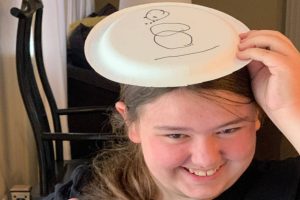 Snowman Paper Plate Game with teen girl laughing