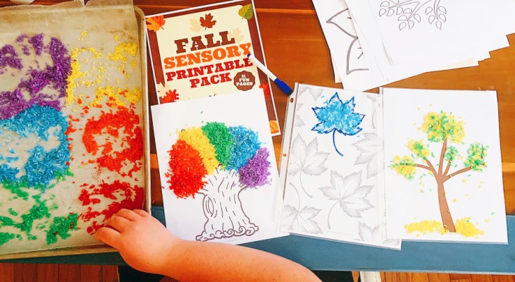 Autumn Sensory Activity with child's hand on a sensory table with dyed rice and fall tree printables