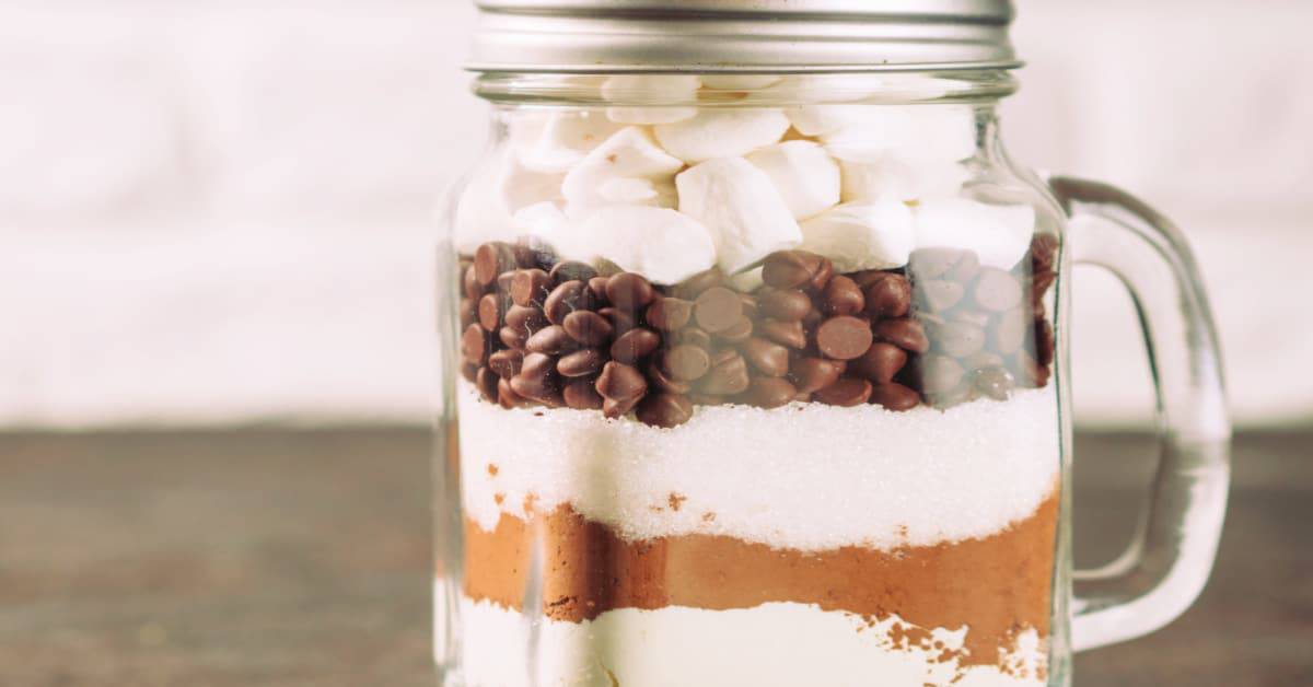 layered hot cocoa gift jar recipe in a mason jar mug