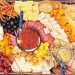how to make your own graze board with top view of charcuterie grazing board with different meats cheeses crackers dips and vegetables