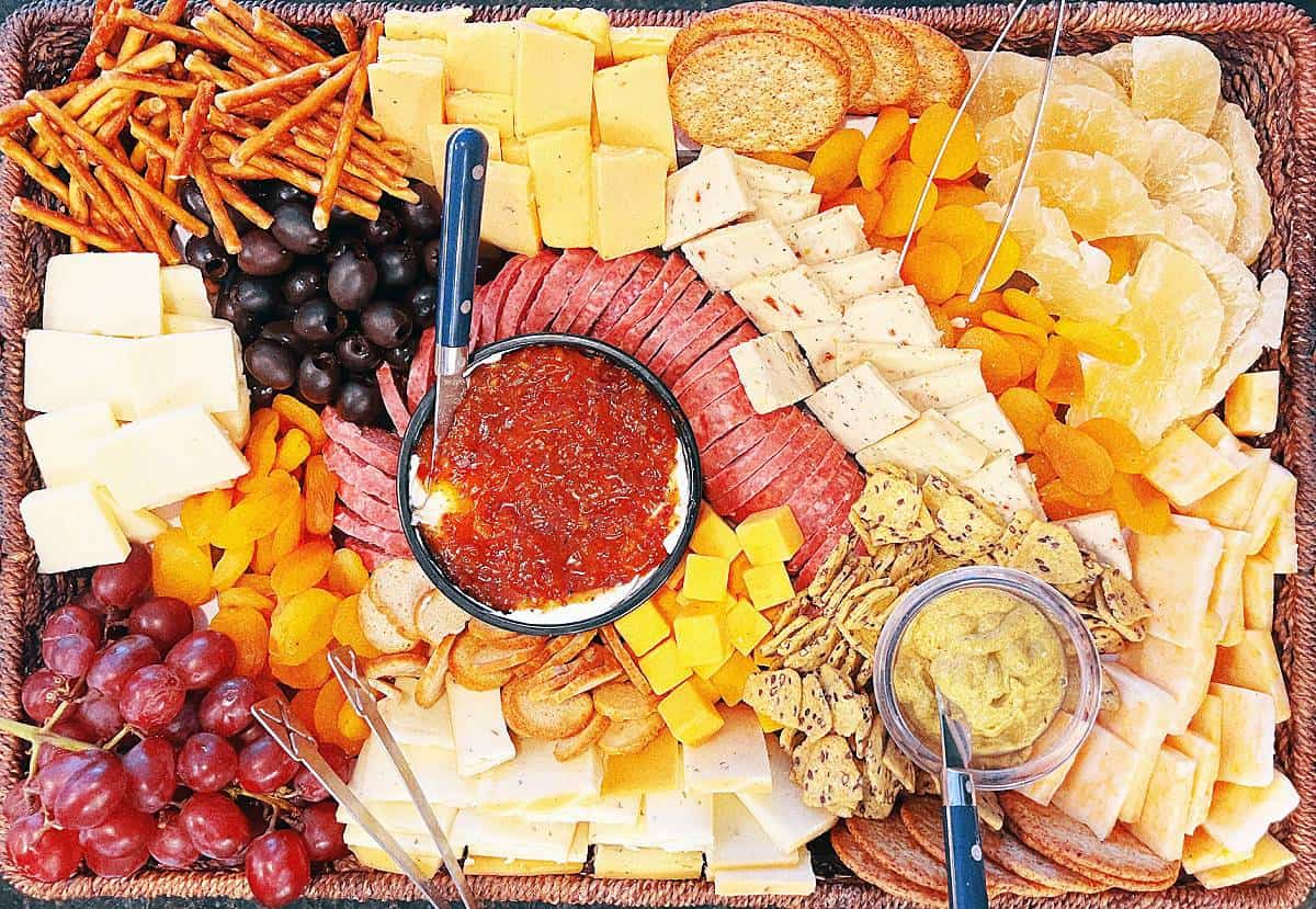 how to make your own graze board with top view of charcuterie grazing board with different meats cheeses crackers dips and vegetables