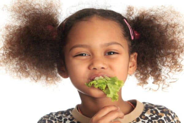 How To Improve Children's Eating Habits young girl with lettuce in her mouth