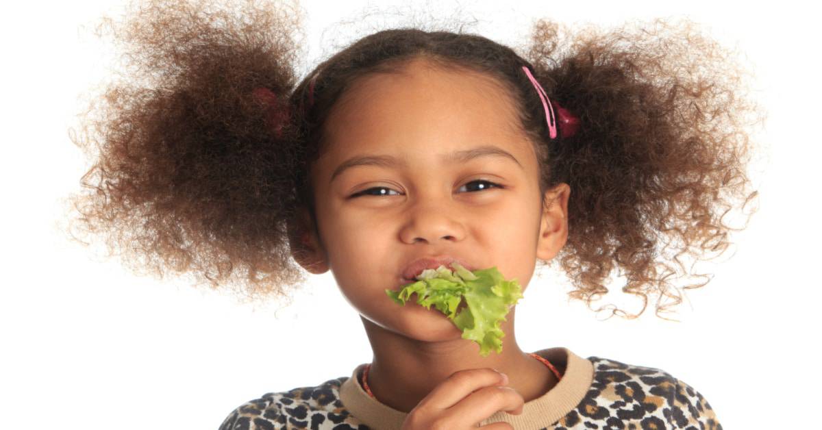 How To Improve Children's Eating Habits young girl with lettuce in her mouth