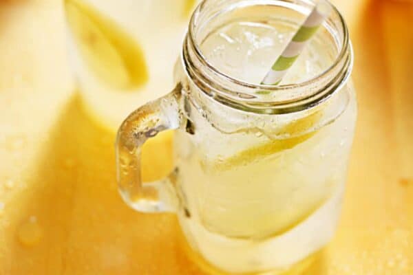 how to make homemade lemonade easy recipe (how to make lemonade at home recipe) fresh lemonade in a mason jar on a table