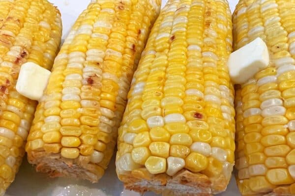 Air Fryer Corn On The Cob Summer Recipe close up of air fried sweet corn with butter on the corn cobs