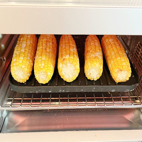How long do you cook corn air fryer close up of corn air frying in air fryer oven