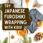 Japanese furoshiki wrapping cloths text over top down view of fabric wrapped presents on a white table with nature decorations like pinecones, dried oranges, and evergreen leaves