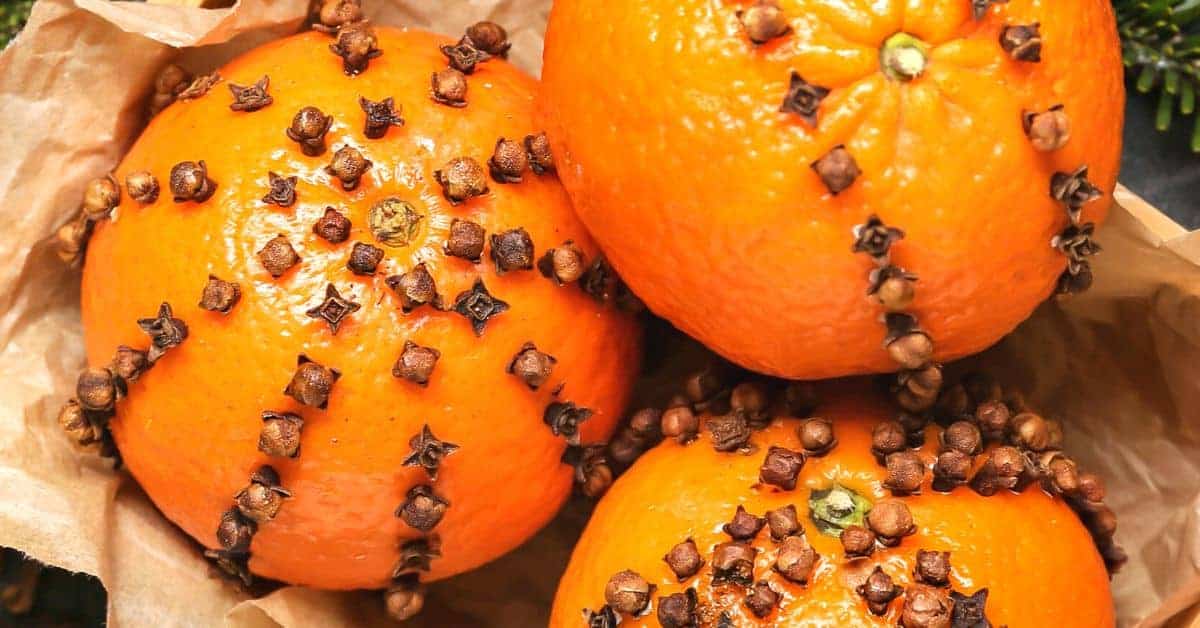 How To Make An Orange Clove Pomander (orange with cloves stuck in it sitting on table)