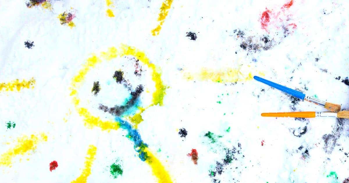 Paint The Snow Activity (Winter Paint Ideas For Kids) yellow sun painted on real snow with food colour vibrant dots around it