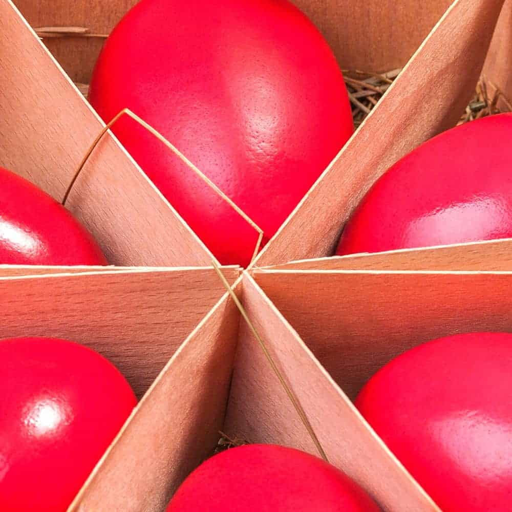 What does red eggs mean? (eggs that are color red symbolize what?) dye red eggs separated by pieces of cardboard