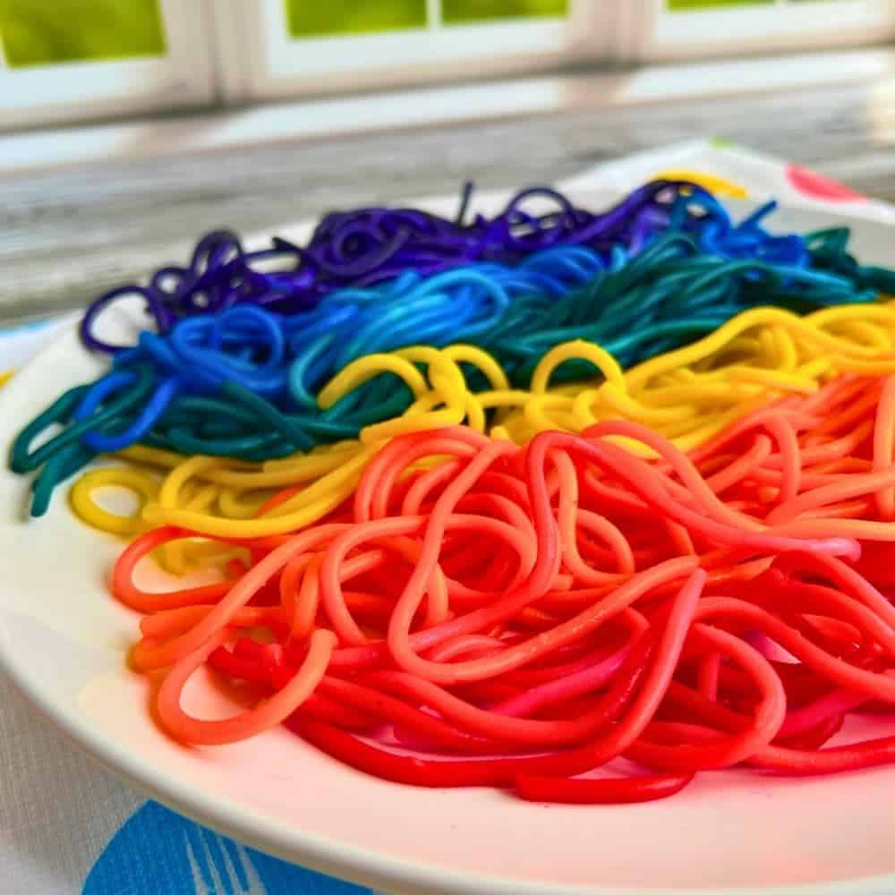 How To Make Colored Spaghetti For Eating rainbow pasta on a plate in front of a window
