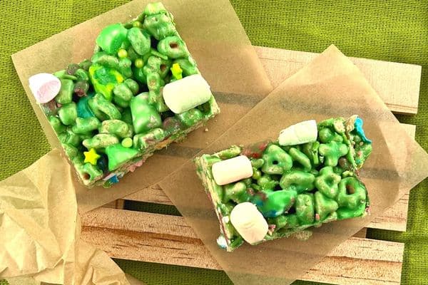 Lucky Charms St Patrick's Day rice krispies recipe on brown parchment paper sitting on green dishtowel