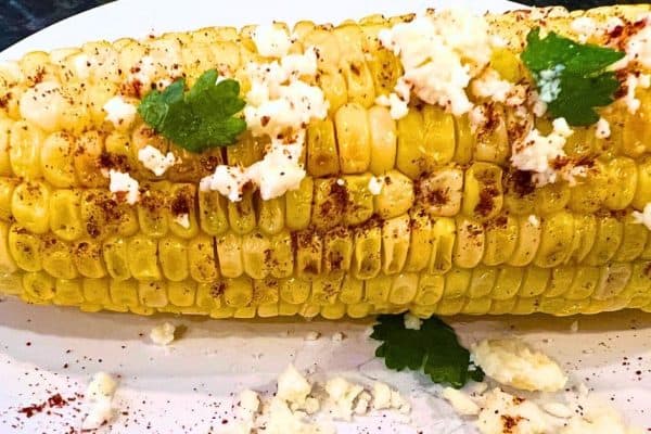 Corn On The Cob Mexican Style Recipe (Elote Mexicano) on a plate with elotes toppings