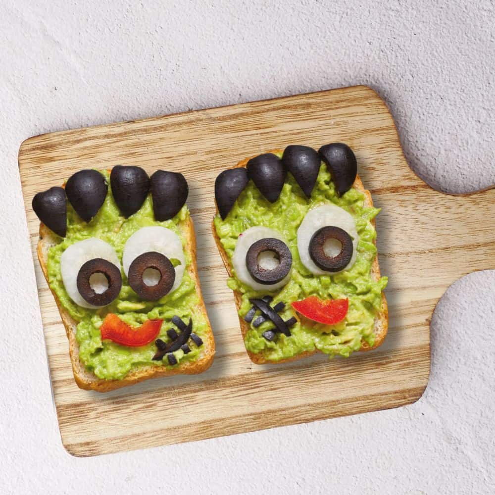 Halloween Green Monster Frankenstein Toast Halloween breakfast avocado toast with a face of Frankenstein monster