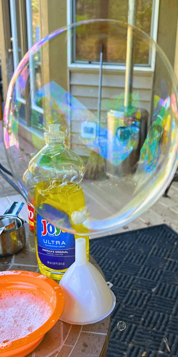 Make Your Own DIY Bubble Station Bubbles At Home (DIY bubble solution recipe for the best bubble mixture) big homemade bubble floating over bubble craft ingredients