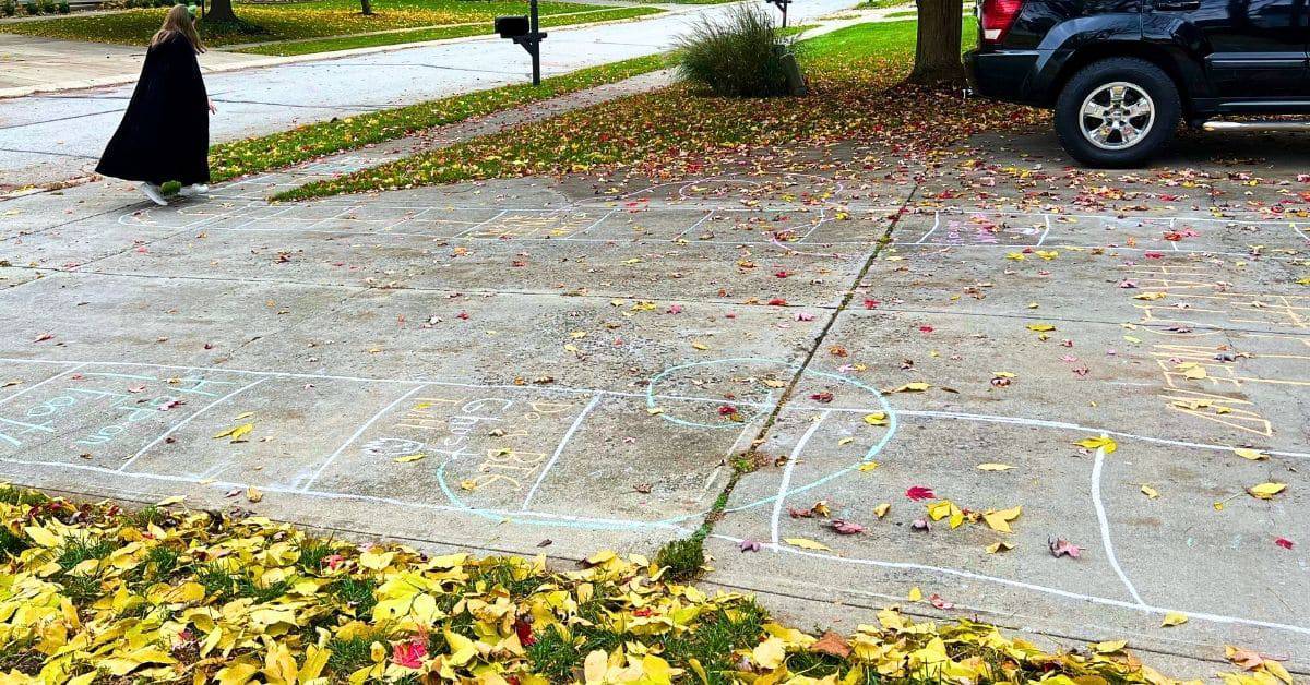 Halloween Hopscotch Game chalk hopscotch on a drive way with a teen dressed up as a vampire doing the Halloween hopscotch board outdoors